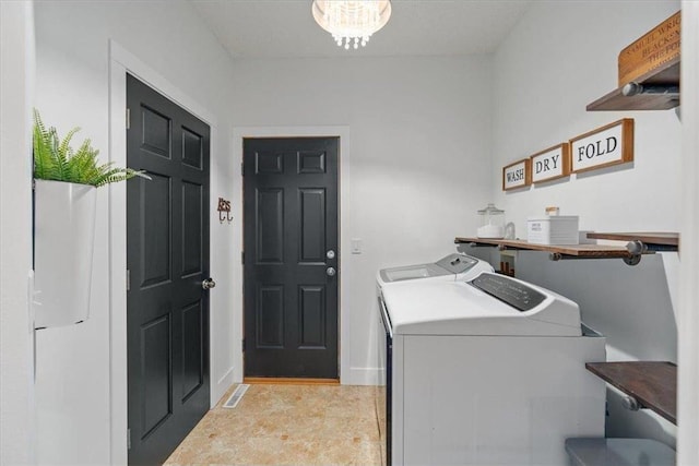 washroom with laundry area, independent washer and dryer, and an inviting chandelier