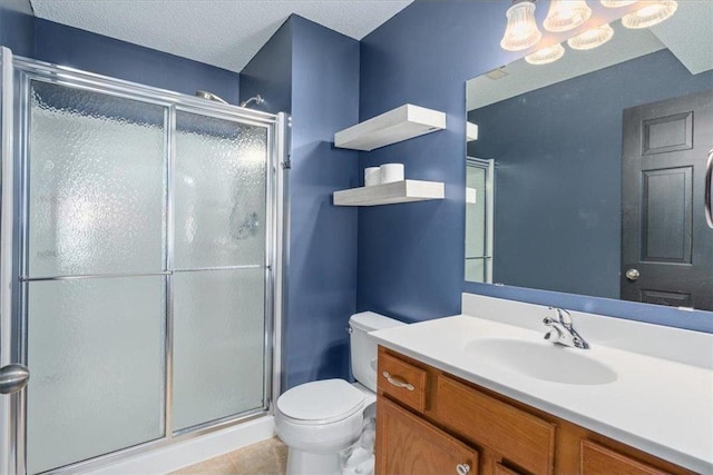 bathroom featuring a stall shower, toilet, tile patterned flooring, a textured ceiling, and vanity