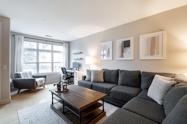 living area featuring light wood finished floors and baseboards