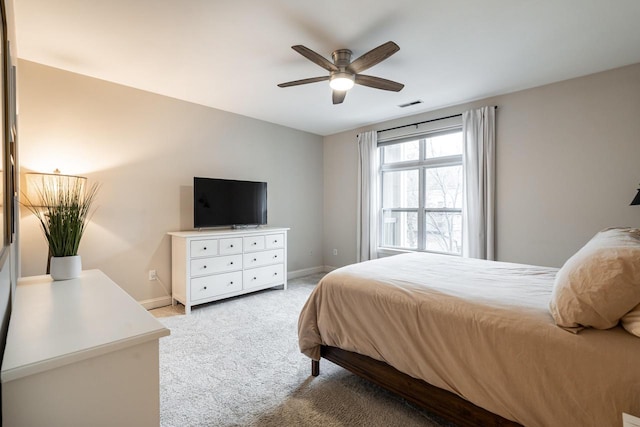 bedroom featuring baseboards, ceiling fan, visible vents, and light colored carpet