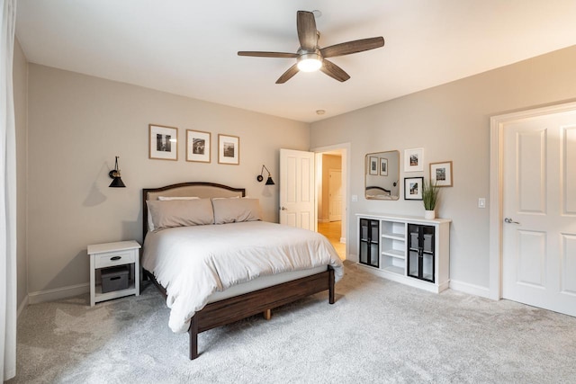 carpeted bedroom with ceiling fan and baseboards