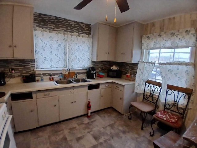 kitchen featuring tasteful backsplash, light countertops, and a sink