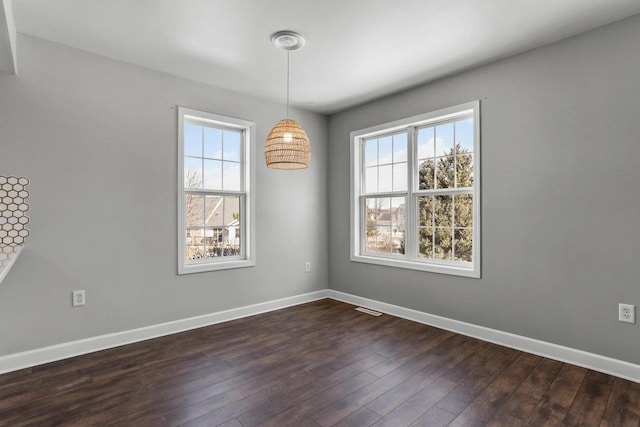 unfurnished dining area with dark wood-style floors and baseboards