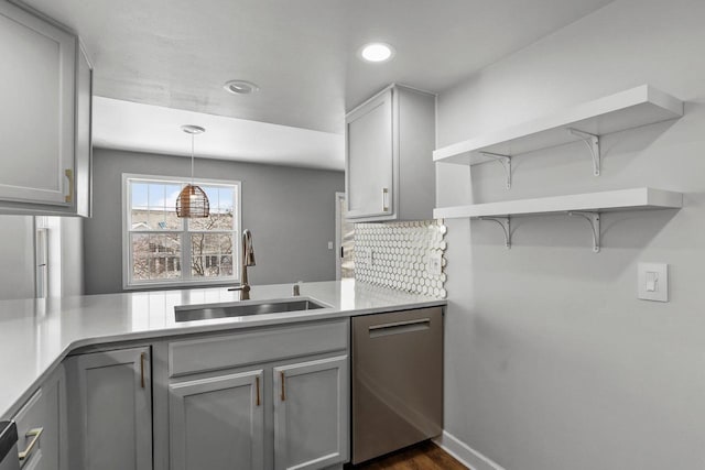 kitchen with gray cabinetry, dishwasher, a sink, and open shelves