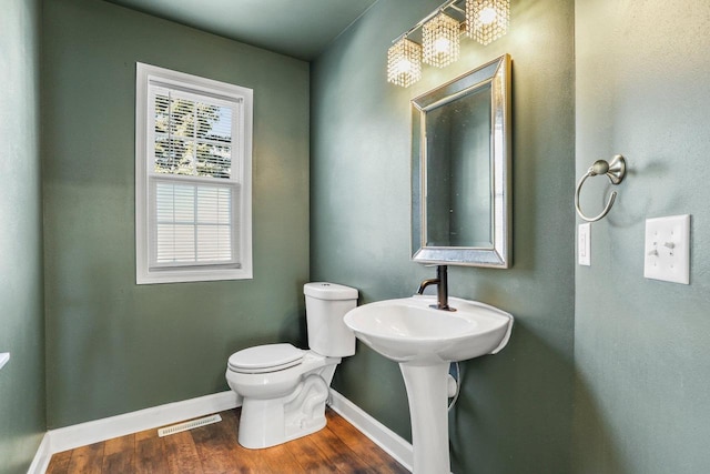 bathroom featuring visible vents, wood finished floors, toilet, and baseboards