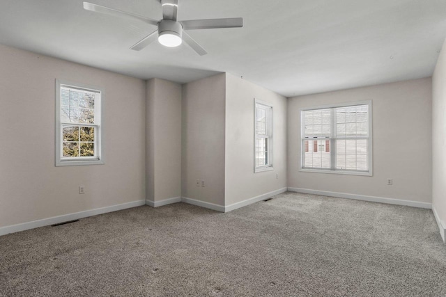 unfurnished room featuring a ceiling fan, carpet, visible vents, and baseboards