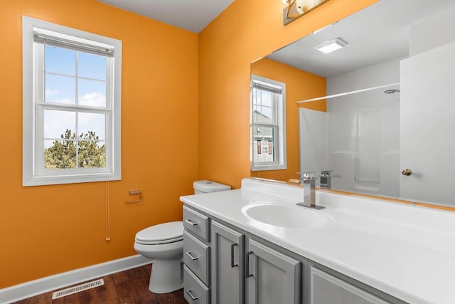 full bath with toilet, wood finished floors, vanity, visible vents, and a shower