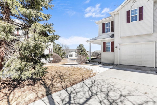 view of home's exterior with an attached garage and concrete driveway