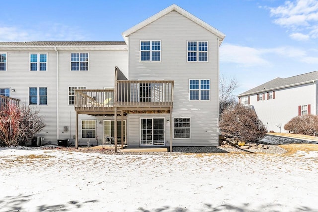 snow covered house featuring central AC and a wooden deck