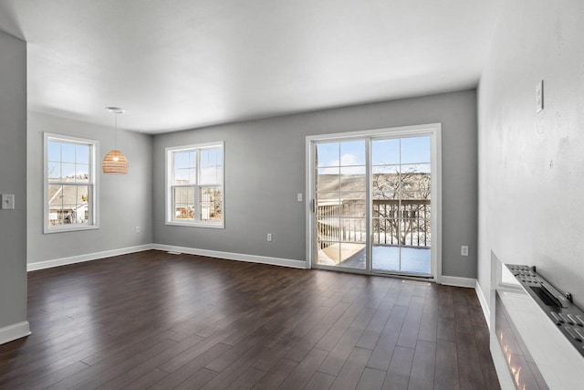 unfurnished living room featuring dark wood-style floors and baseboards