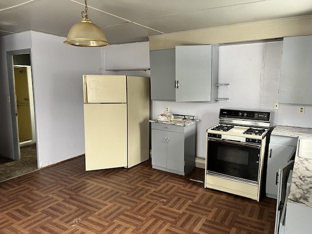 kitchen with hanging light fixtures, gas range oven, light countertops, and freestanding refrigerator