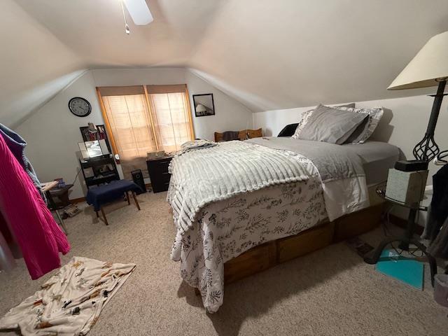 bedroom with vaulted ceiling, carpet floors, and a ceiling fan