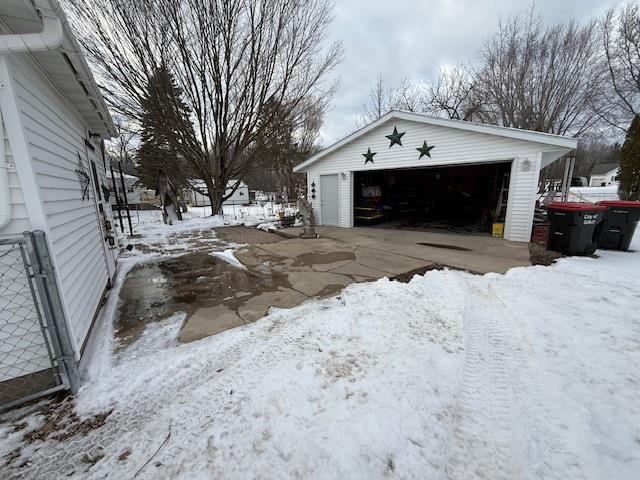 snow covered garage with a detached garage