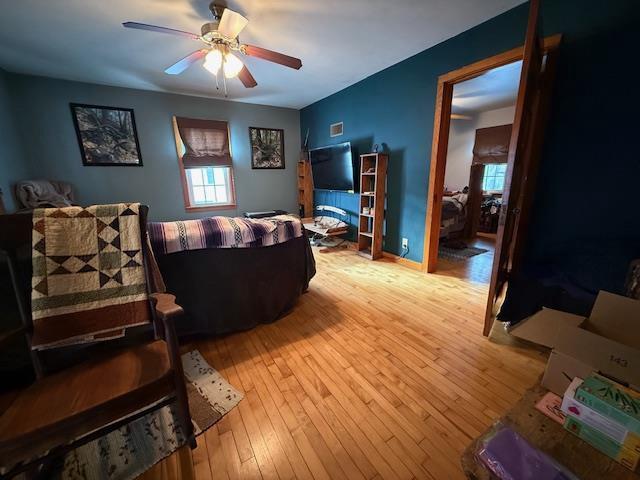 living area with light wood finished floors and ceiling fan