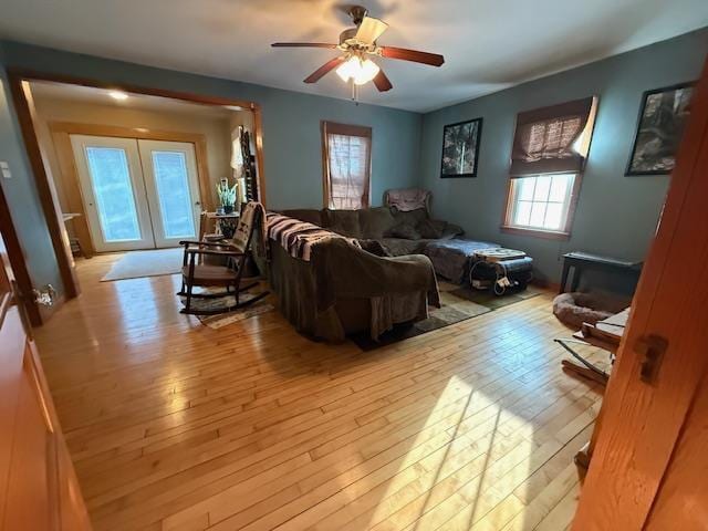 living room featuring ceiling fan, french doors, and hardwood / wood-style floors