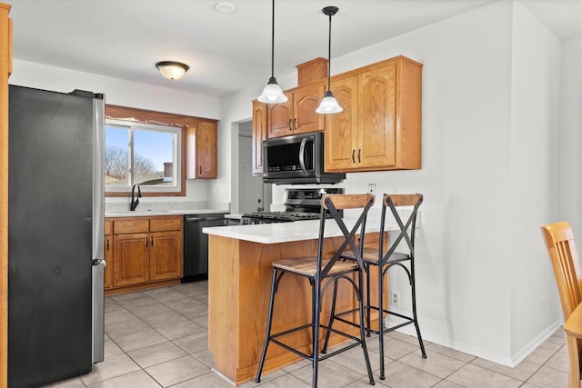 kitchen with stainless steel appliances, a breakfast bar, a peninsula, a sink, and light countertops