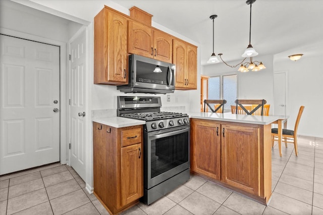 kitchen featuring light tile patterned floors, a peninsula, hanging light fixtures, appliances with stainless steel finishes, and light countertops