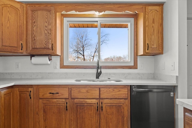 kitchen with dishwashing machine, brown cabinetry, a sink, and light countertops