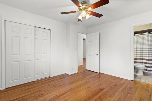 unfurnished bedroom with a closet, connected bathroom, light wood-style flooring, and baseboards