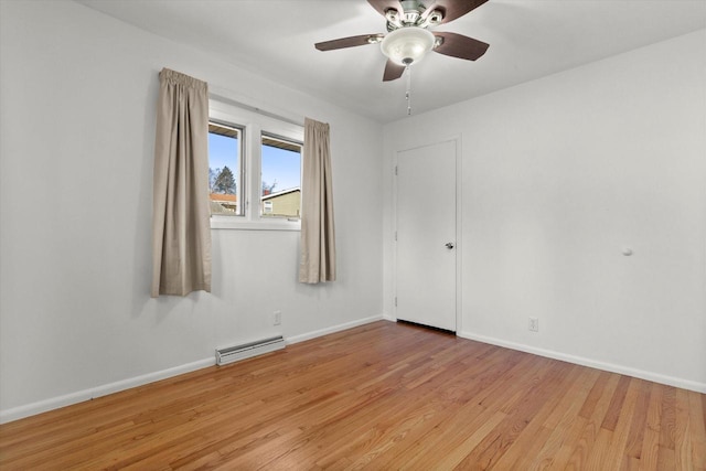 empty room with a baseboard heating unit, ceiling fan, light wood finished floors, and baseboards