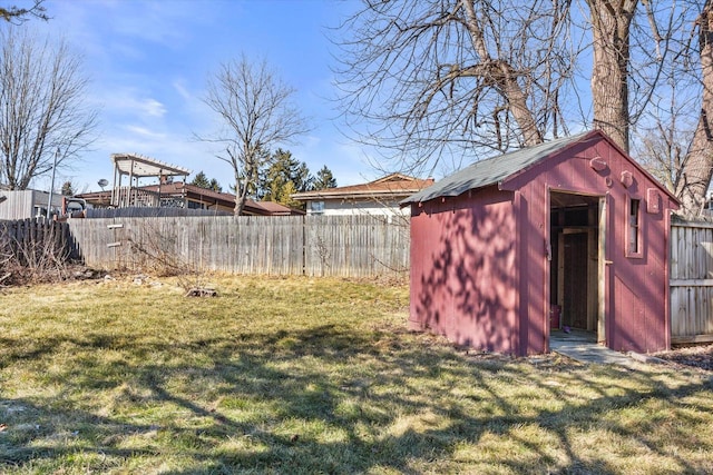 view of yard with an outbuilding, a shed, and a fenced backyard