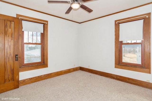 carpeted empty room featuring ceiling fan, ornamental molding, and baseboards