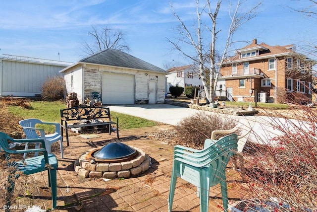 exterior space with an outbuilding, a patio area, an outdoor fire pit, and a detached garage