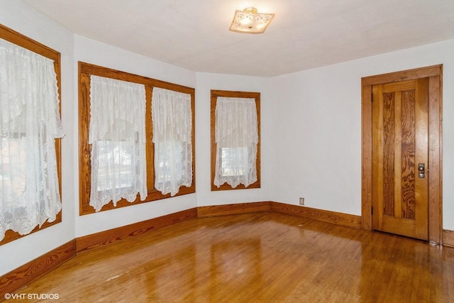 unfurnished room with wood finished floors and baseboards