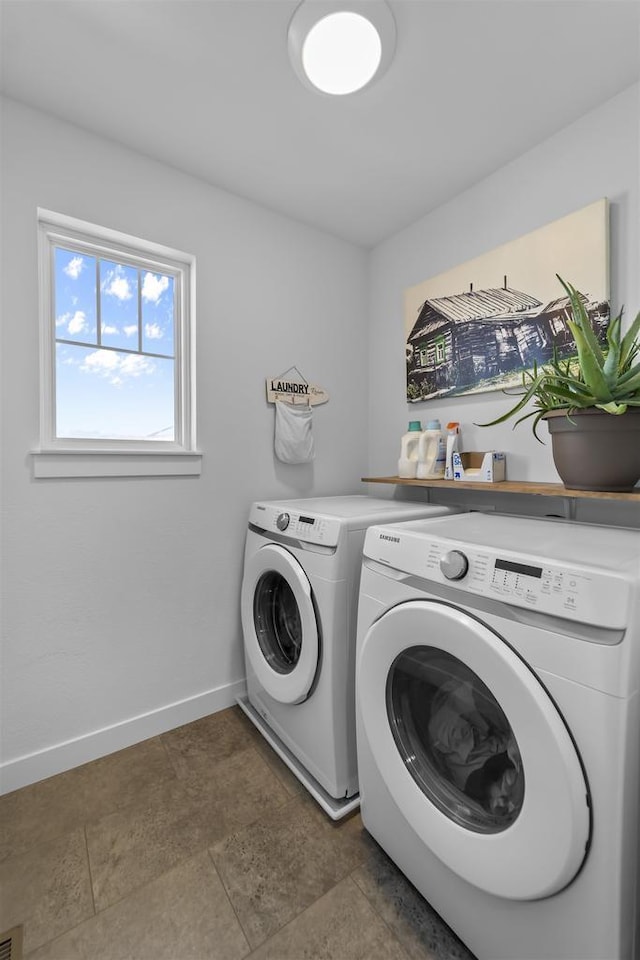 washroom featuring washer and dryer, laundry area, and baseboards