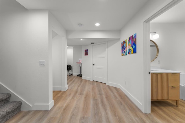 hall with stairway, recessed lighting, light wood-style flooring, and baseboards