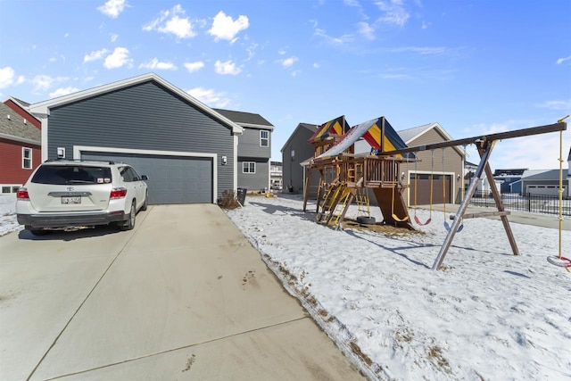 view of front facade featuring an attached garage, driveway, a playground, and fence