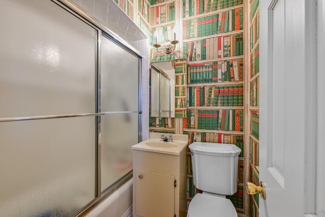 full bath featuring enclosed tub / shower combo, toilet, wallpapered walls, and vanity