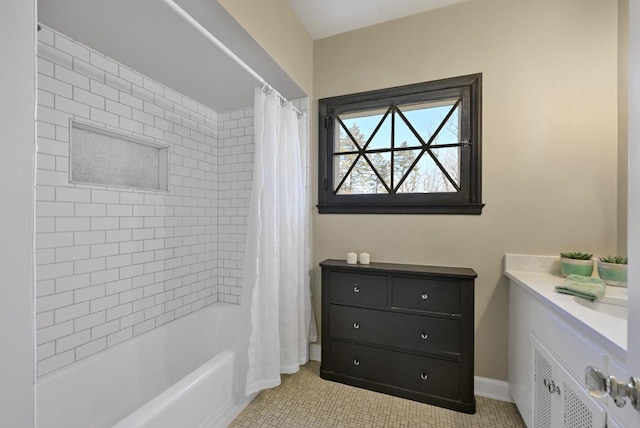 full bath featuring tile patterned floors, baseboards, vanity, and shower / tub combo