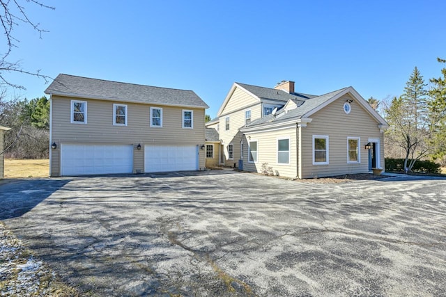 exterior space with aphalt driveway and an attached garage