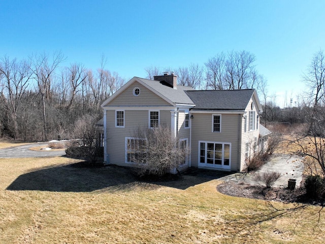 rear view of house with a lawn and a chimney