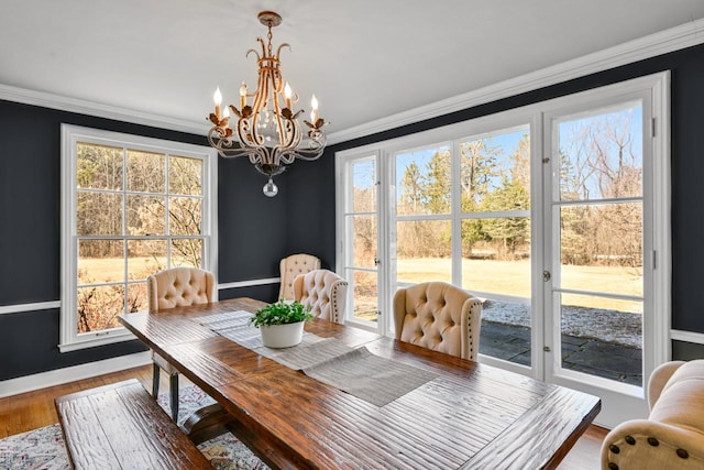 dining room with a chandelier, wood finished floors, baseboards, and ornamental molding