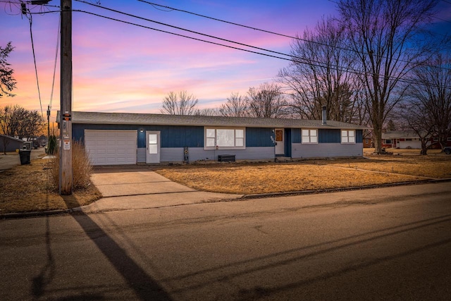 ranch-style house with concrete driveway and an attached garage