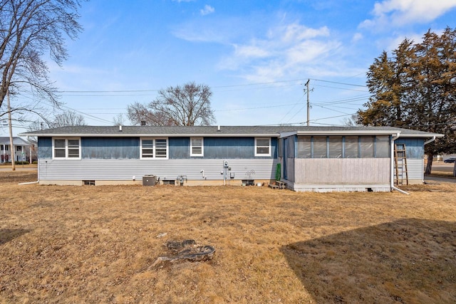 view of front of house featuring a front lawn, cooling unit, and a sunroom