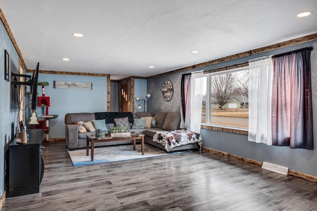 living room featuring baseboards, visible vents, wood finished floors, and recessed lighting