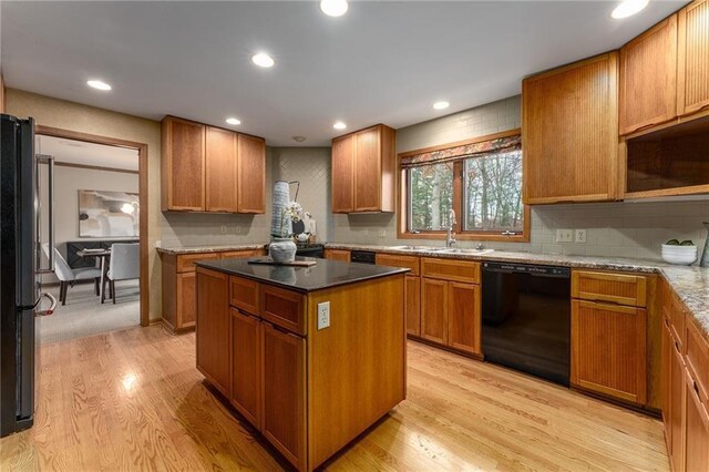 614 Westwood Dr, Chippewa Falls, WI 54729 - kitchen with black appliances, a kitchen island, light wood-style floors, and a sink