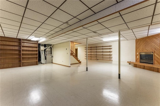 614 Westwood Dr, Chippewa Falls, WI 54729 - finished basement featuring heating unit, a paneled ceiling, stairway, tile patterned floors, and a glass covered fireplace