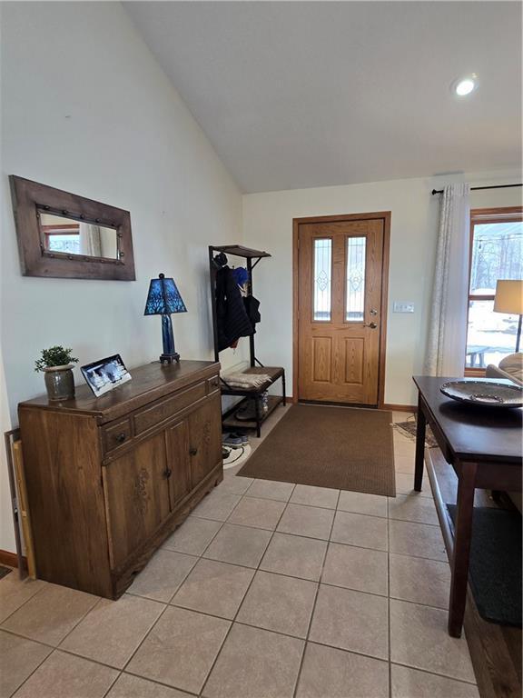 entrance foyer with vaulted ceiling and light tile patterned floors