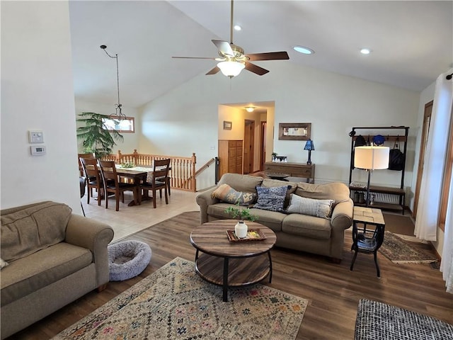 living area featuring high vaulted ceiling, a ceiling fan, and wood finished floors