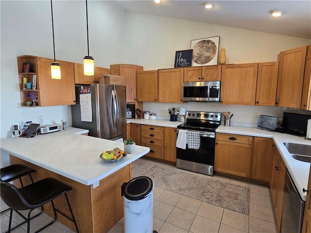 kitchen with a breakfast bar, brown cabinets, light tile patterned floors, stainless steel appliances, and a peninsula