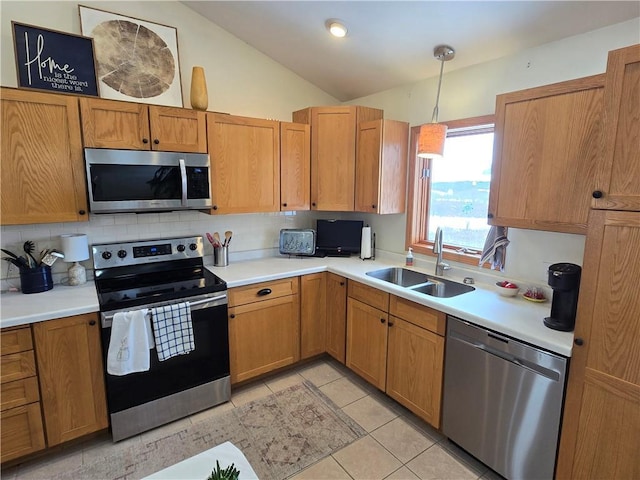 kitchen featuring lofted ceiling, stainless steel appliances, a sink, and light countertops