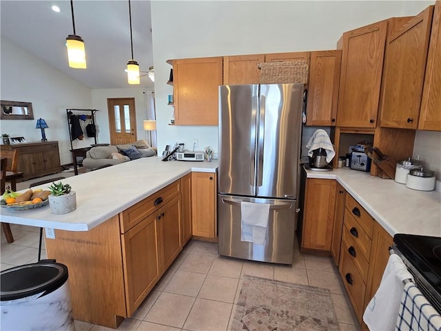 kitchen featuring light tile patterned floors, stainless steel appliances, light countertops, hanging light fixtures, and a peninsula