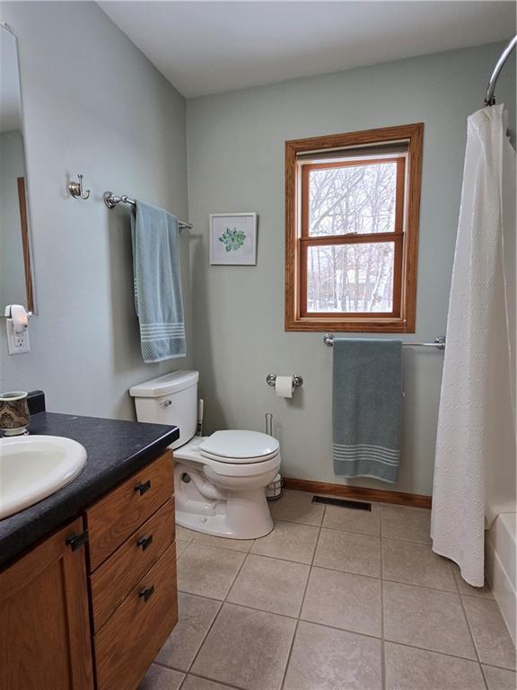 bathroom featuring toilet, tile patterned flooring, visible vents, and vanity