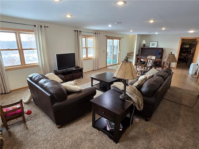 living area with baseboards, recessed lighting, light colored carpet, and a healthy amount of sunlight