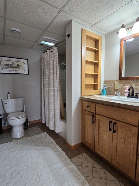 bathroom with visible vents, built in features, toilet, tile patterned flooring, and vanity