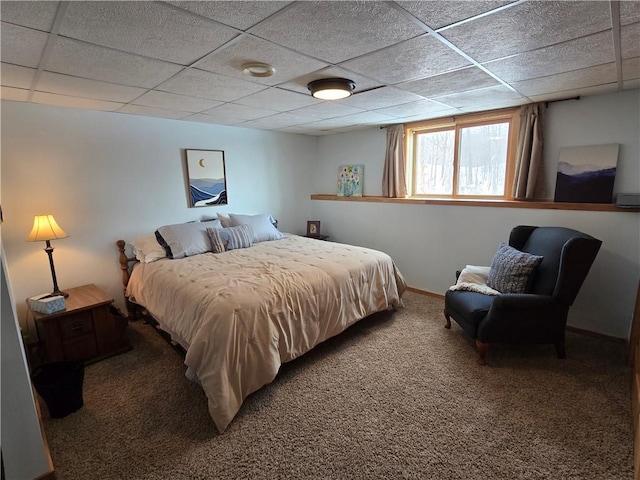 carpeted bedroom with a drop ceiling and baseboards